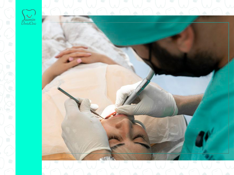 تصویری از دکتر امیر فلاح در حال جراحی دندان بیمار خانوم در کلینیک دندان پزشکی سامین